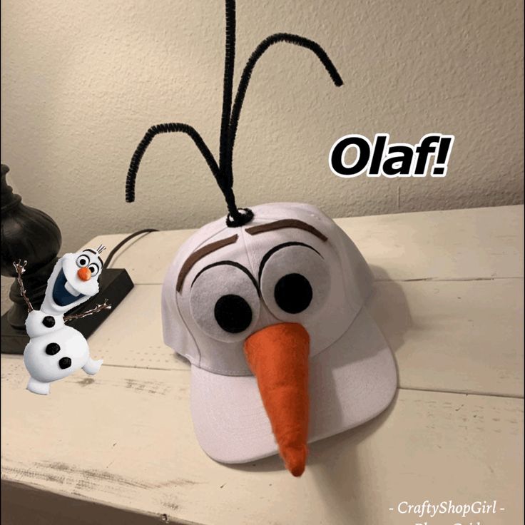 a snowman hat hanging from the side of a table next to a stuffed animal