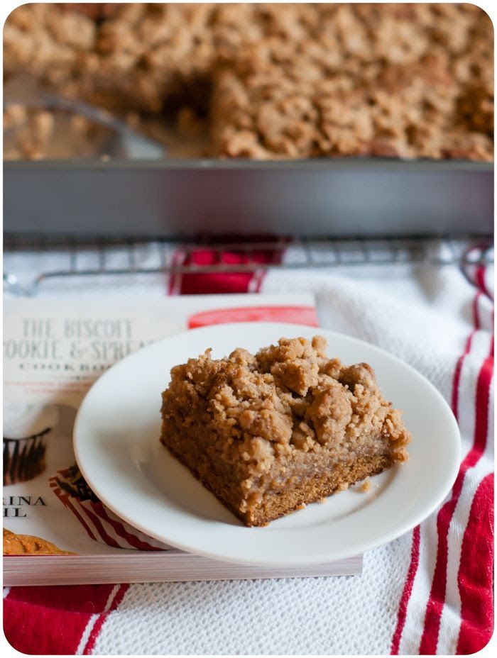 a white plate topped with a piece of cake next to a pan of oatmeal