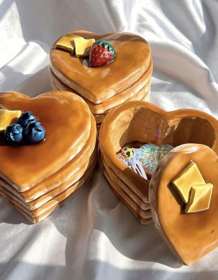 four heart shaped cakes are stacked on top of each other with cheese and fruit in them