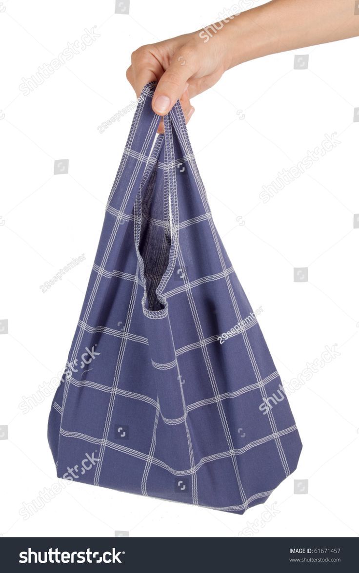 a hand holding a blue shopping bag on white background