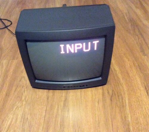 an old computer monitor with the word imput written on it sitting on a wooden floor