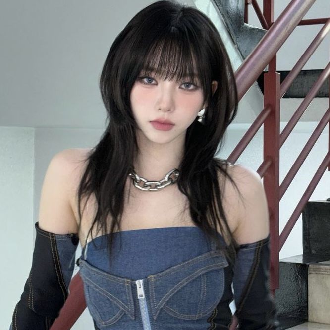 a woman with long black hair wearing a denim dress