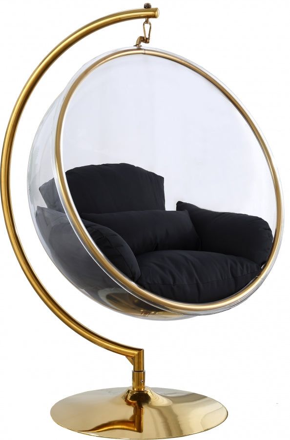 a round mirror sitting on top of a metal stand next to a black couch in it