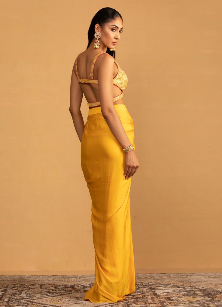 Embrace the chic and contemporary take on tradition with the Yellow Pre-Draped Dhoti Top Set, an ensemble that exudes elegance and modernity. Crafted from georgette, the exquisite yellow top features beautifully crafted gota work, offering a luxurious feel and eye-catching shimmer. Paired with a pre-draped dhoti designed to provide both comfort and style, the vibrant yellow hue adds a touch of brightness, ensuring you stand out with grace and poise. A perfect indo fusion ensemble choice for Haldi, Mehndi, Sangeet ceremonies or as wedding guest attire. Composition : Blouse - Georgette, Dhoti - Satin Georgette Care: Dry Clean Only and Vacuum Storage This product can be customized for sleeves, length and colour Delivery : 4-6 weeks as the product is hand crafted. Check Size Guide or choose My Dhoti Top, Gota Work, Vacuum Storage, Indian Wedding Wear, Guest Attire, Wedding Attire Guest, Yellow Top, Wedding Wear, The Chic