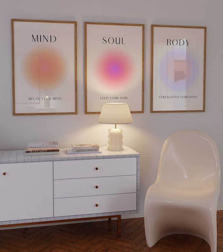 a room with two posters on the wall and a white chair in front of it