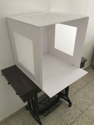 a white box sitting on top of a wooden table next to a wall and floor