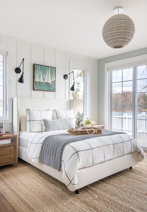 a large bed sitting next to two windows in a bedroom