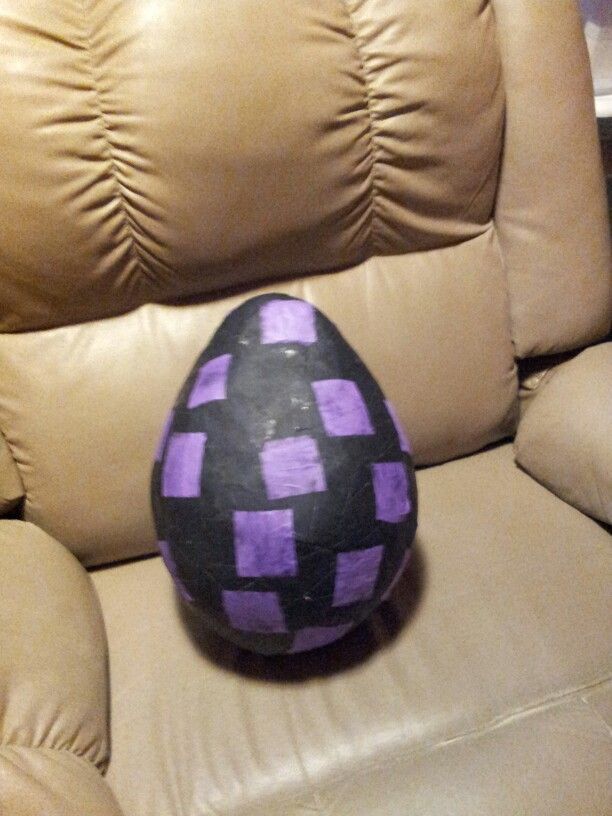 a purple and black ball sitting on top of a brown leather chair