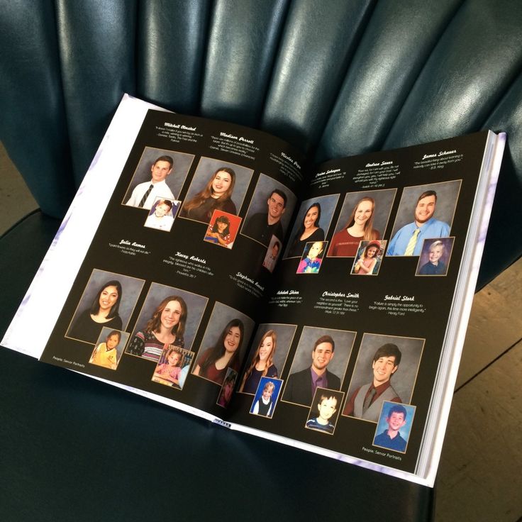 an open book with pictures of people on it sitting on a blue leather chair in front of a wooden table