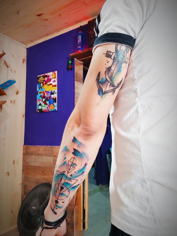 a man's arm with an anchor tattoo on it