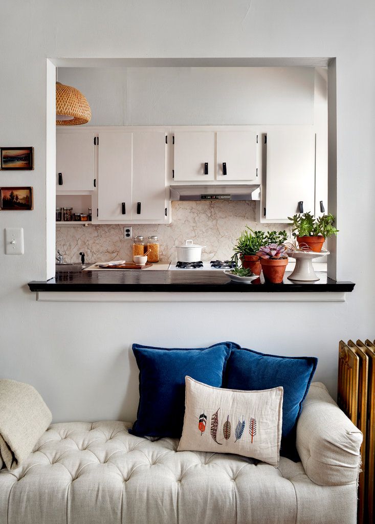 a kitchen with white cabinets and blue pillows