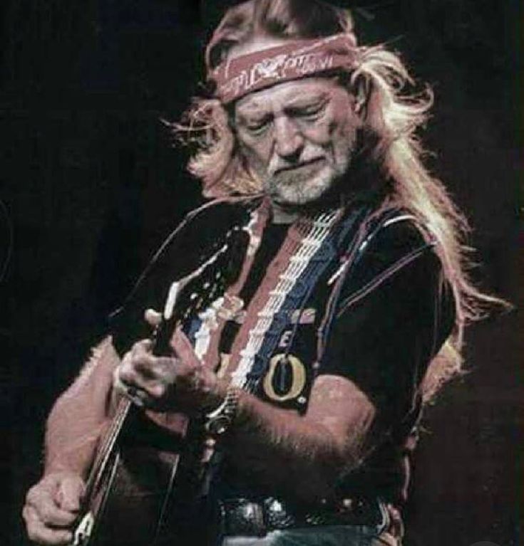 an old man with long hair playing a guitar