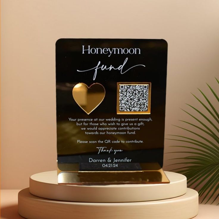 a plaque with a gold heart on it sitting on a table next to a potted plant