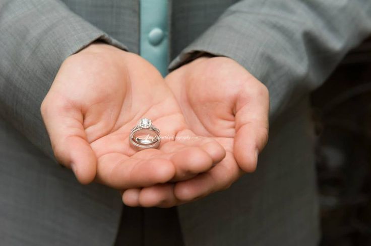 a man in a suit holding his wedding ring