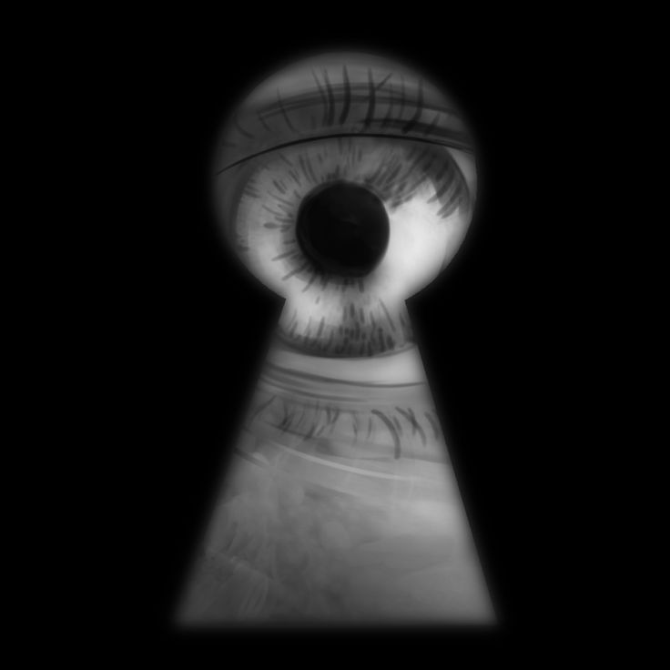 an eye looking through a keyhole in the dark