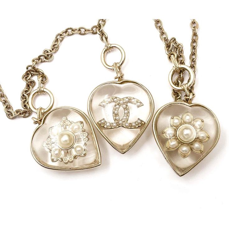 This is part of Chairish’s Costume Jewelry assortment.  Chanel Gold CC Flower Heart Charm Necklace  *Marked 16 *Made in France *Comes with the original box and dustbag  -It is approximately 34" long. -The heart pendants are approximately 2" x 1". -In an excellent condition Luxury Sterling Silver Heart Necklace, Luxury Heart Pendant Necklace, Luxury Double Heart Necklace, Luxury Heart-shaped Charms Necklace, Luxury Heart-shaped Jewelry With Detachable Pendant, Luxury Heart Necklace For Wedding, Luxury Silver Necklace With Flower Charm, Luxury Heart Necklace With 17 Jewels, Designer Heart-shaped Wedding Jewelry