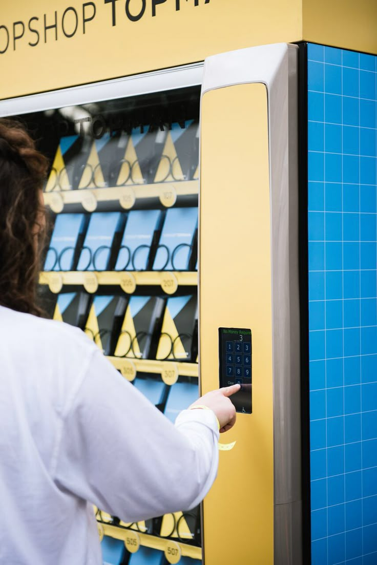 a woman is using an atm machine to check out items