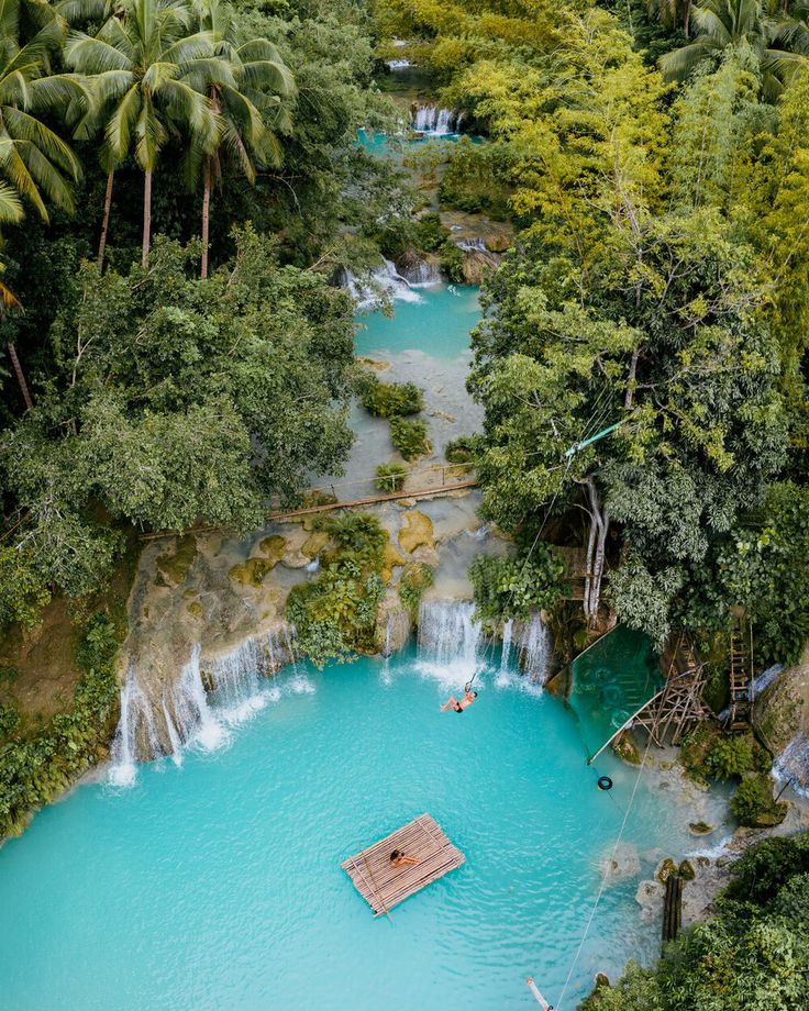 an aerial view of a blue pool surrounded by trees