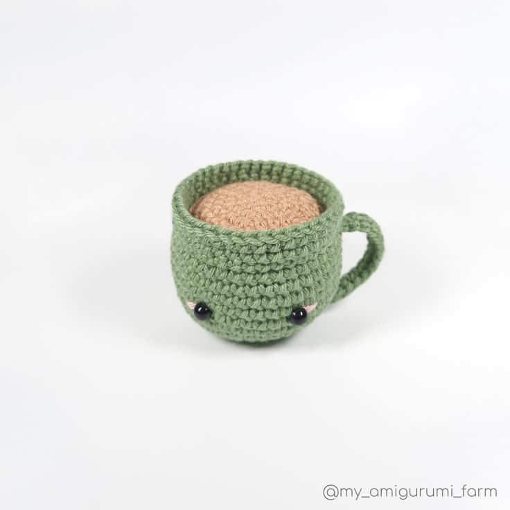 a crocheted coffee cup is sitting on a white surface