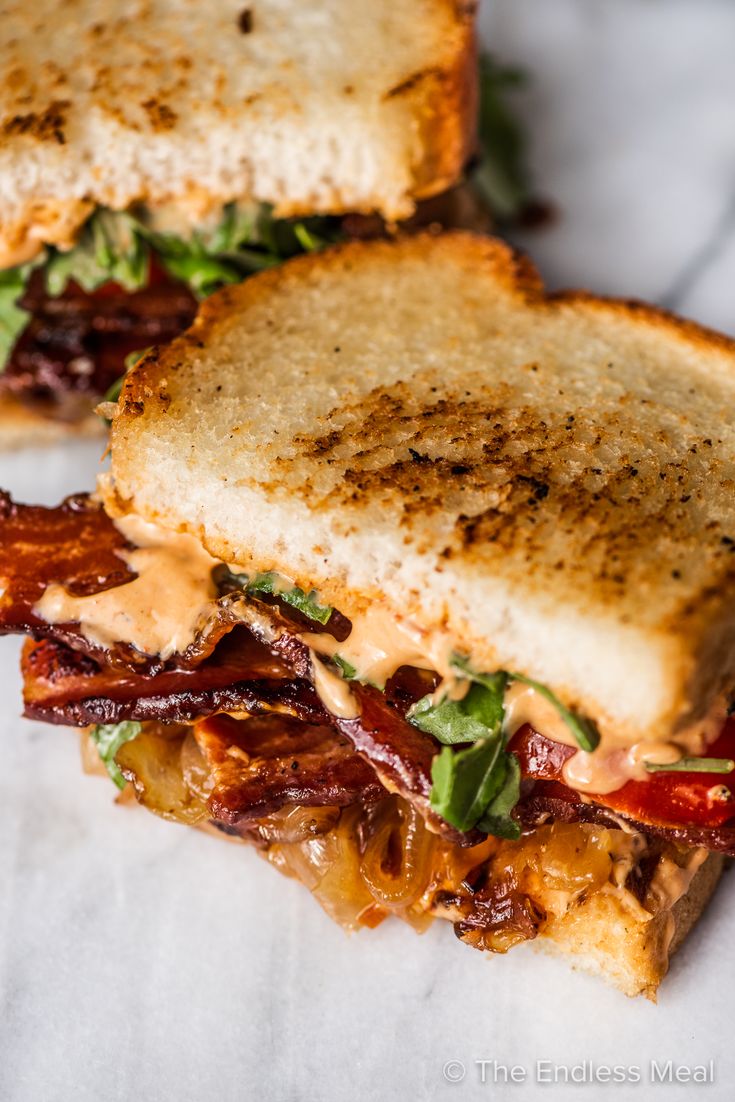 two grilled sandwiches with bacon and lettuce on toasted bread