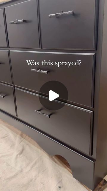 a black dresser with the words was this sprayed? on it's bottom drawer