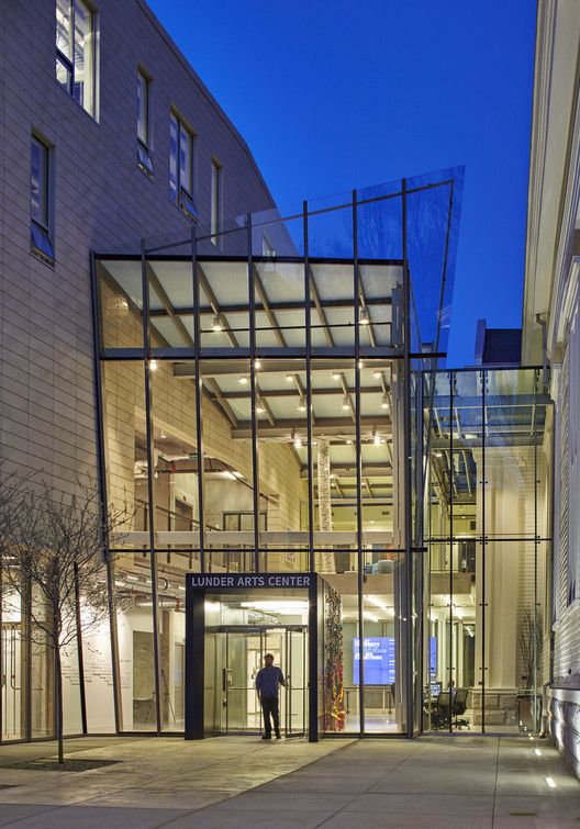 a man is standing in front of the entrance to an office building at night time