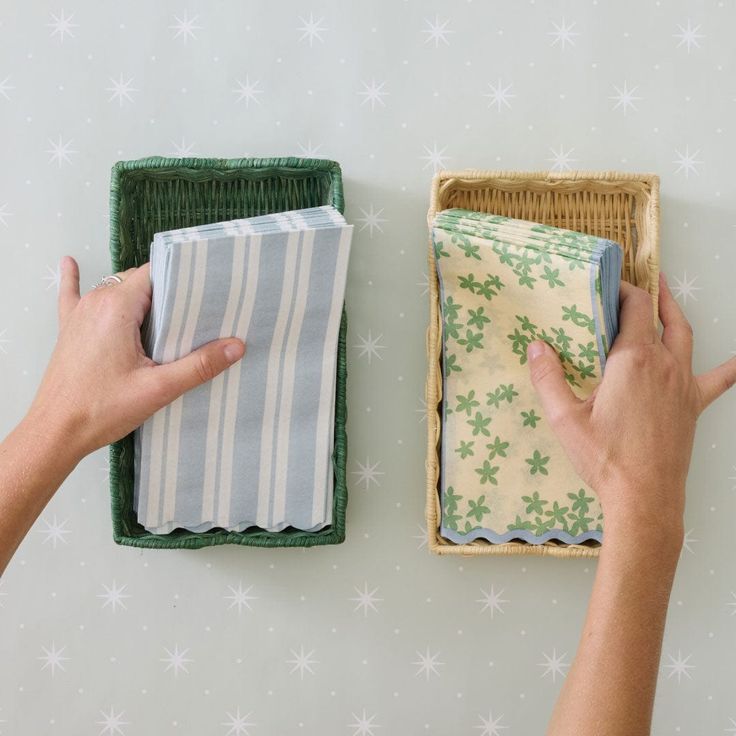 two hands holding cloths next to an empty basket