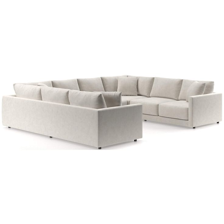 a white sectional couch and ottoman in front of a white background, with the back section facing