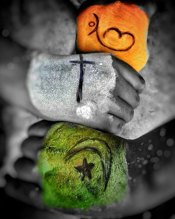 two hands holding an orange and a cross on top of each other with hearts painted on them