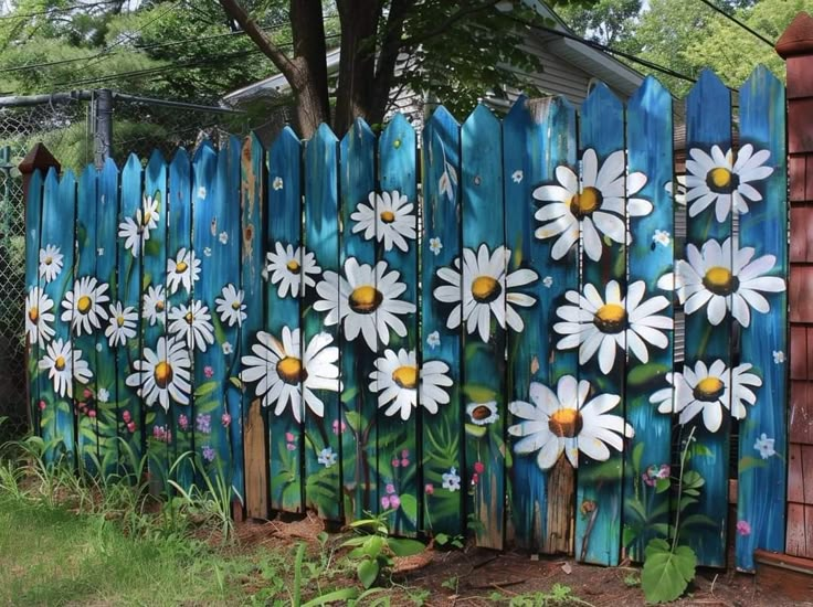 a wooden fence with painted daisies on it