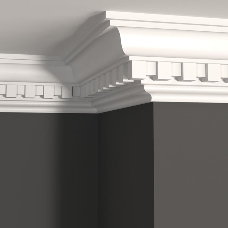 the corner of a room with black walls and white molding on the ceiling,