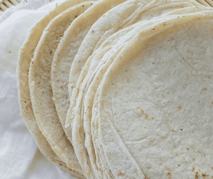 a stack of tortillas sitting on top of a white napkin