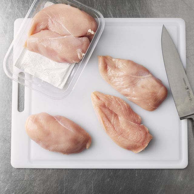 three pieces of chicken sitting on top of a cutting board next to a knife