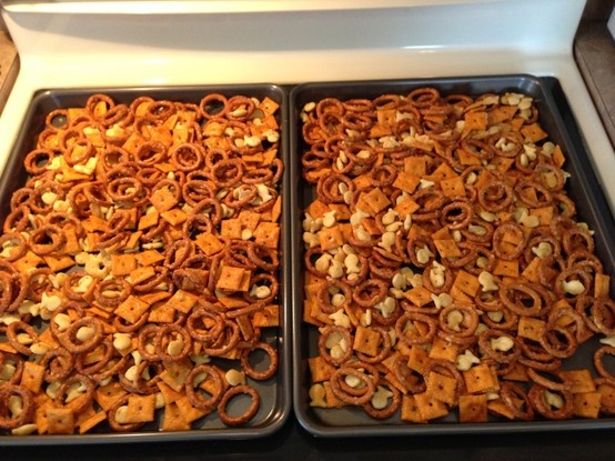 two trays filled with food sitting on top of a stove