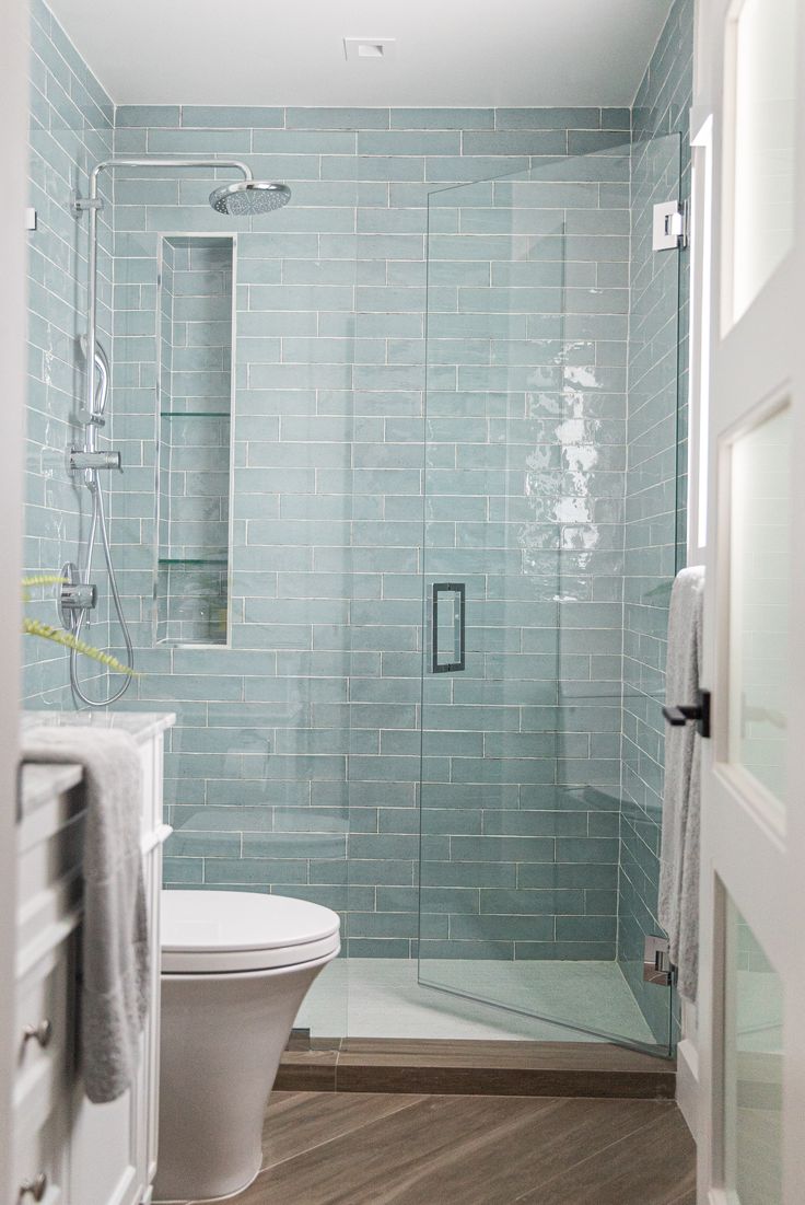 a white toilet sitting next to a walk in shower