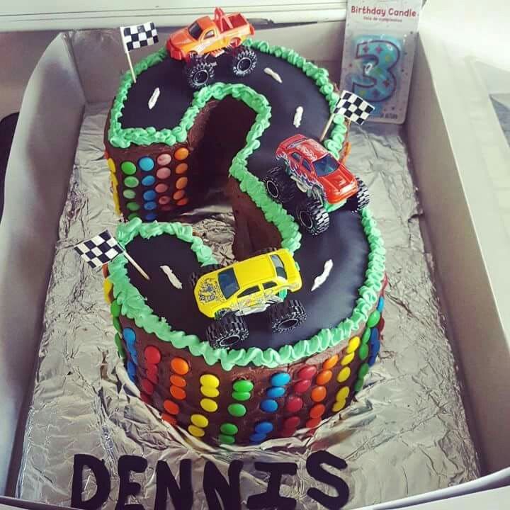 a birthday cake in the shape of a number with cars and numbers on it,