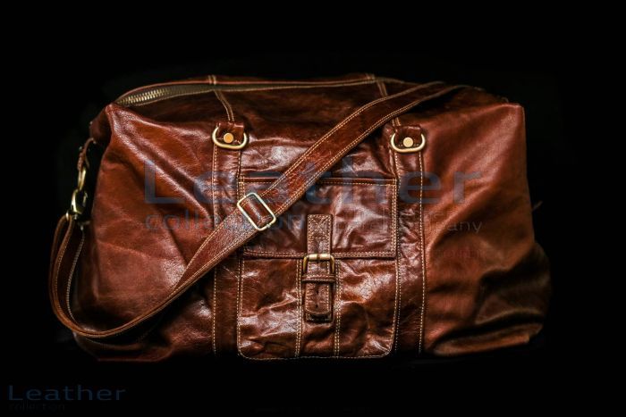 a brown leather duffel bag on a black background