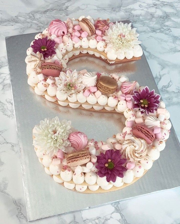 a cake shaped like the letter s with flowers on it