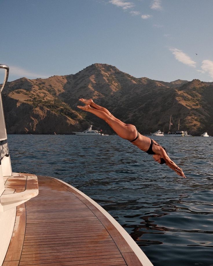 a man diving into the water from a boat