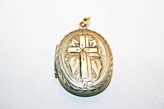 Antique Victorian silver locket, circa 1890s. In good condition, with minor wear and dings commensurate to age; along one edge of the cross, there is a hairline gap in the engraving, where the instrument used to emboss the locket's surface split through the metal. See photos for condition and measurements. Antique Collectible Crucifix Jewelry, Antique Crucifix Collectible Jewelry, Antique Collectible Cross Jewelry, Victorian Engraved Crucifix Jewelry, Vintage Antique Silver Cross Pendant, Silver Cross Pendant For Wedding, Vintage Antique Silver Cross Jewelry, Vintage Cross Jewelry With Antique Finish, Vintage Engraved Cross Jewelry