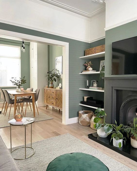 a living room filled with furniture and a flat screen tv mounted on a wall above a fire place