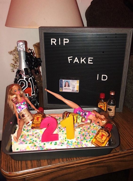 two barbie dolls are laying on top of a fake birthday cake that says rip fake