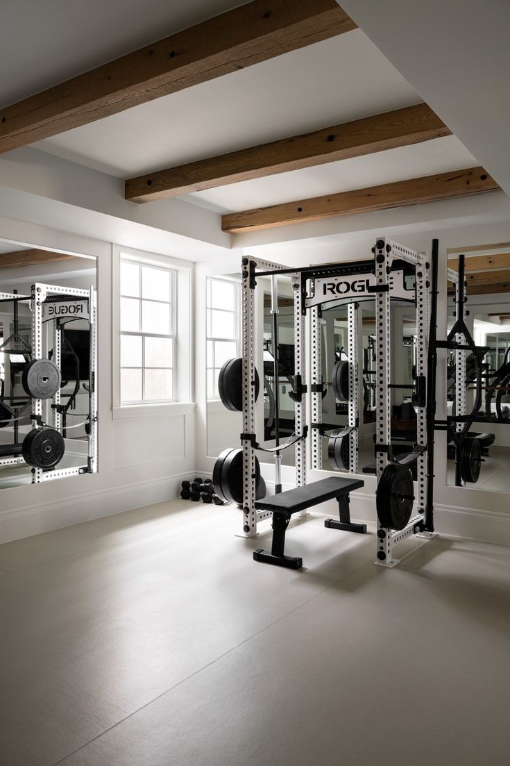 an empty gym room with equipment and mirrors