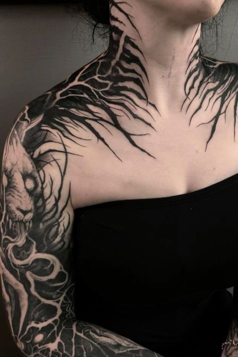 a woman with tattoos on her neck and chest is looking at the camera while wearing a black dress