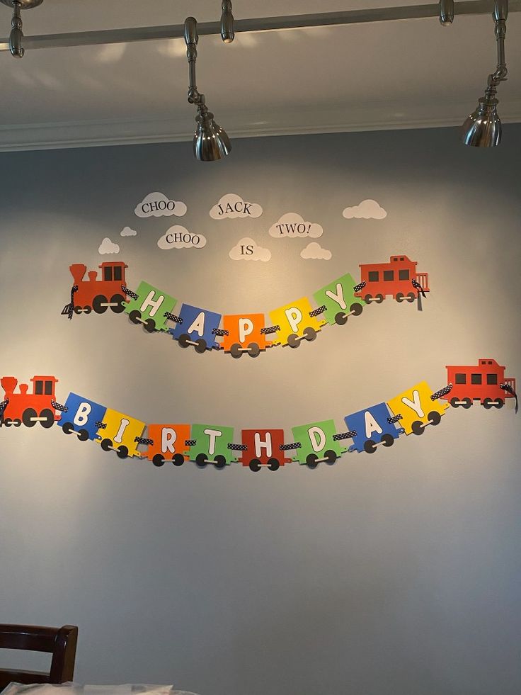 a train themed birthday banner hanging from the ceiling