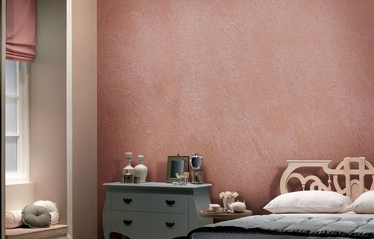 a bedroom with pink walls and white furniture