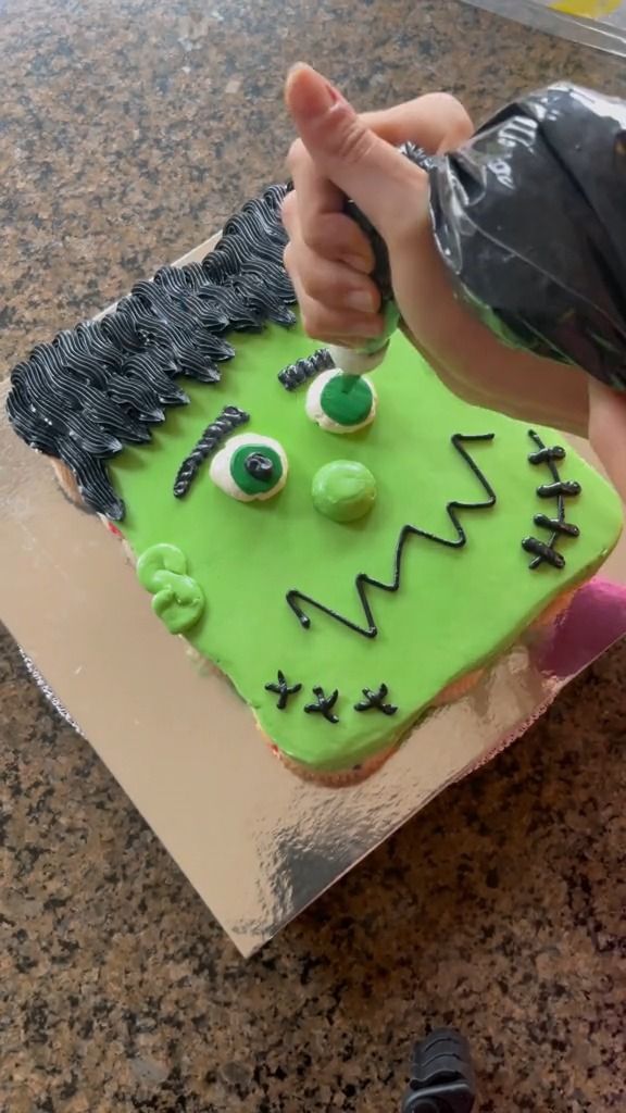 a cake shaped like a monster with green eyes