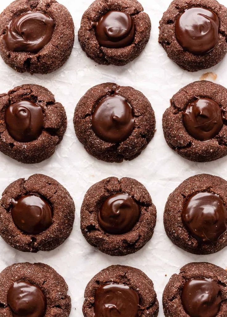 chocolate cookies are lined up in rows on a baking sheet with melted chocolate frosting