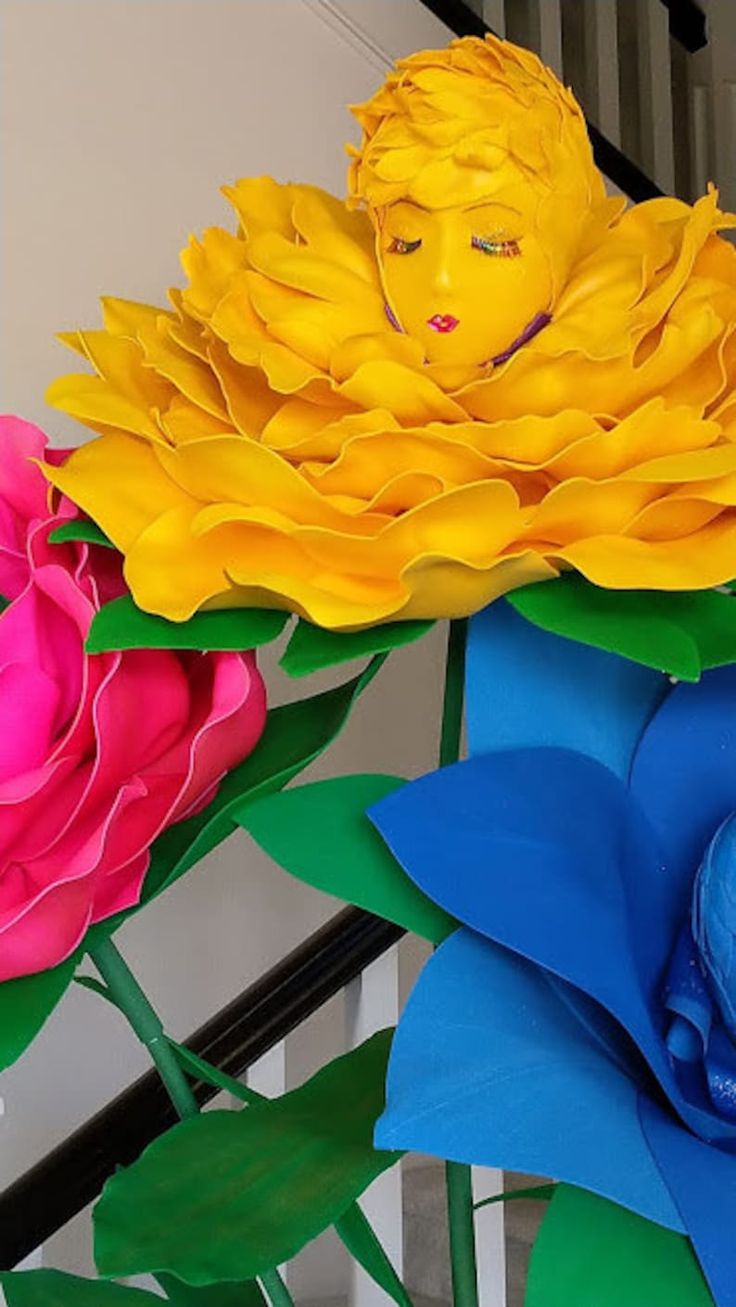 colorful paper flowers are arranged in the shape of buddha's head, and on top of each other