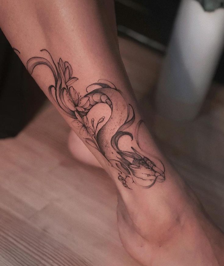 a woman's foot with a dragon tattoo on it